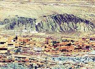 A Landsat TM color composite registered to a DEM (digitized topographic base) data set to yield an oblique perspective view of the White Tank Mountains and adjacent valleys and farmlands.