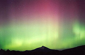 The Northern Lights, seen from the ground; the green color associates with excited oxygen, the red with nitrogen.