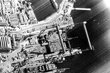 One of the first KH-11 Crystal images, showing facilities at a Soviet harbor; the streaks to the right suggest scan lines, implying that an electro-optical scanner made this image.