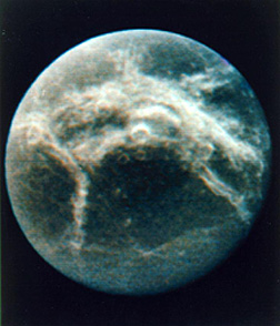 Much of the other side of Dione, in a modified color version in which the broad whitish bands may be widespread ice coming from fissures.